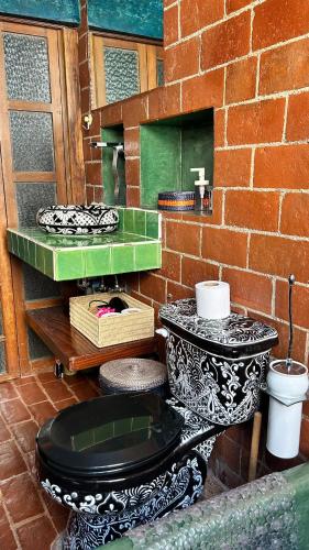 a bathroom with a black and white toilet and a sink at Latidos del Centro de CDMX in Mexico City
