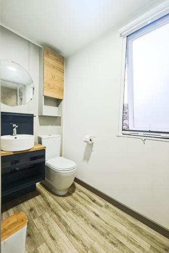 a bathroom with a toilet and a sink and a window at Azor'Oasis in Calhetas