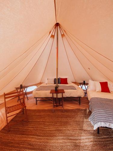 a tent with two beds and a table in a room at Yellowstone Glamping in Henrys Lake Airport