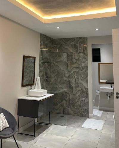a bathroom with a sink and a stone wall at Luxury Property in Kingsborough