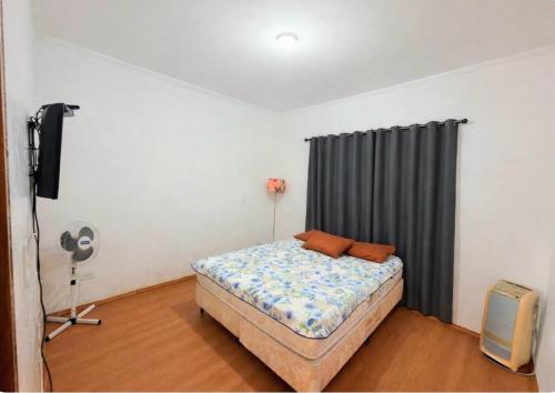 a bedroom with a bed and a tv in it at Chacara Vale do Barreiro in Taubaté