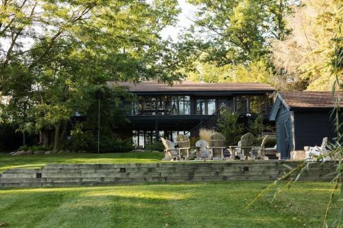 a house with a patio and chairs in the yard at The Great Escape Blocks From Your Private Beach in New Buffalo