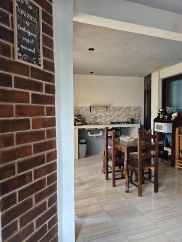 a kitchen and dining room with a brick wall at Home Garden in San Pedro La Laguna