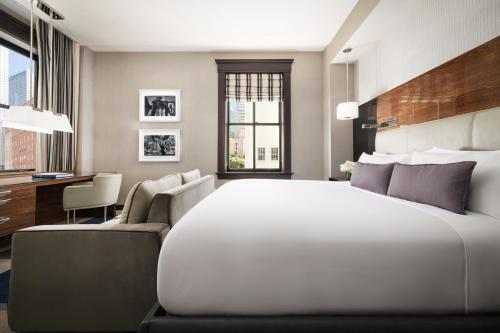 a bedroom with a large white bed and a desk at The Joule Dallas in Dallas