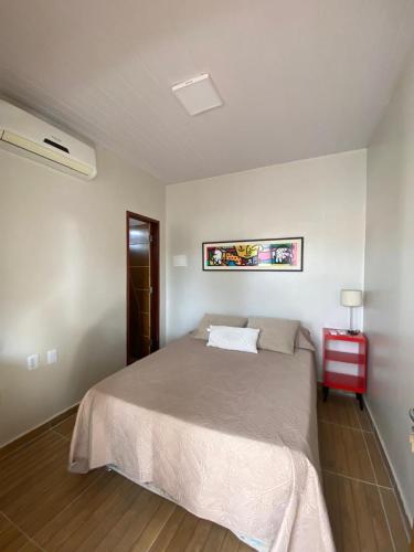a bedroom with a bed and a red end table at Chácara Julião da usina in Juazeiro do Norte