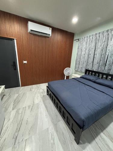 a bedroom with a bed with blue sheets and a window at KaizaHotel Suvarnabhumi Airport in Lat Krabang