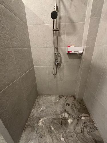 a dirty bathroom with a shower with a muddy floor at KaizaHotel Suvarnabhumi Airport in Lat Krabang