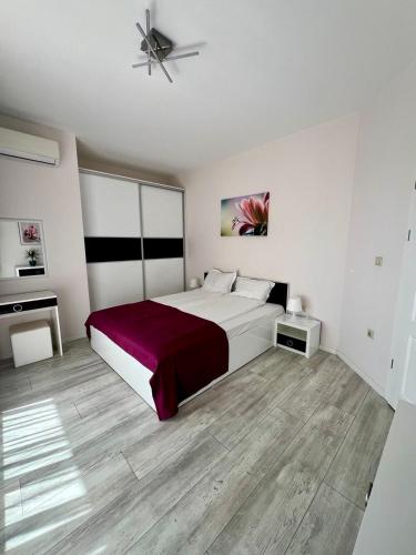 a bedroom with a large bed and a ceiling fan at La Mer Prime Time in Varna City