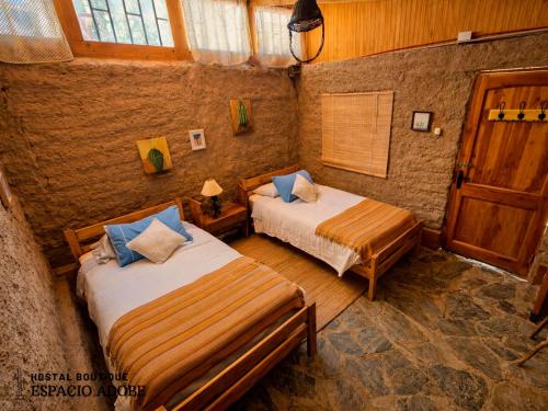 a bedroom with two beds and a window at Espacio Adobe - Hostal Boutique in Diego de Almagro