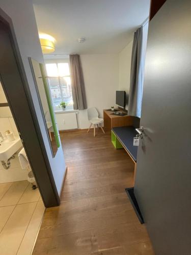 a room with a hallway with a desk and a door at GleisEiNS in Naila