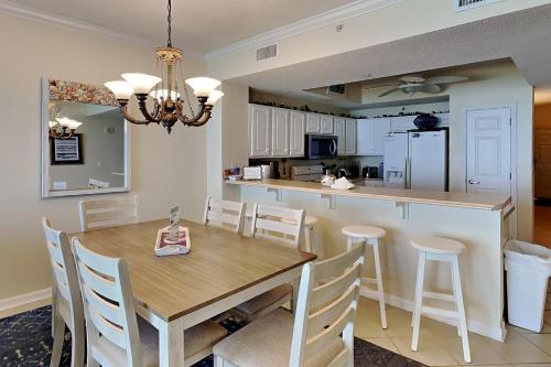 a kitchen and dining room with a wooden table and chairs at Summerwinds #1203 in Navarre