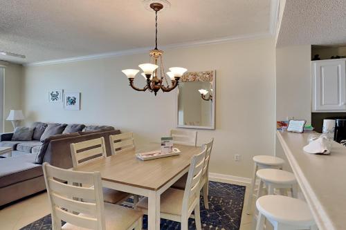 a dining room and living room with a table and chairs at Summerwinds #1203 in Navarre