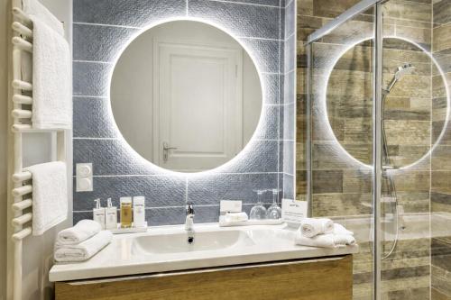 a bathroom with a sink and a mirror at Au jardin de la Basilique in Boulogne-sur-Mer