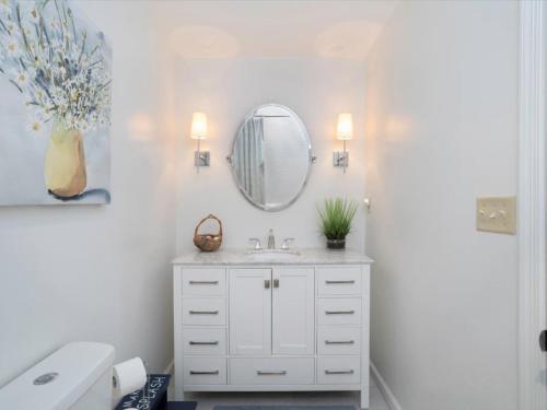 a white bathroom with a sink and a mirror at Covey Creek in Saint Michaels
