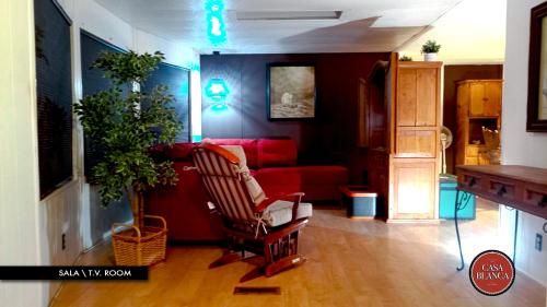 a living room with a red couch and a chair at Casa Blanca Hotel Campestre in Francisco Zarco
