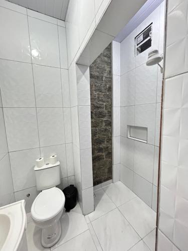 a white bathroom with a toilet and a shower at Pousada Morada Nobre in Barreirinhas