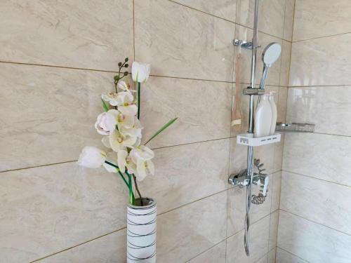 a vase filled with white flowers in a bathroom at Seaview Garden Hotel & Residences in Trinity