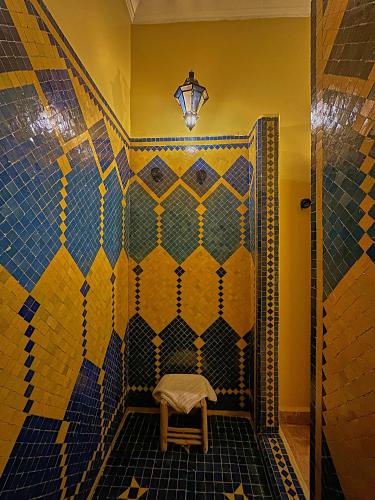 a bathroom with a tiled shower with a stool at Hotel Kasbah Azalay in Mhamid