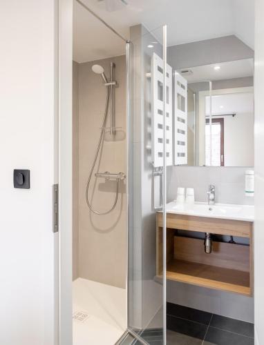 a bathroom with a shower and a sink at Hôtel au Heimbach in Lembach