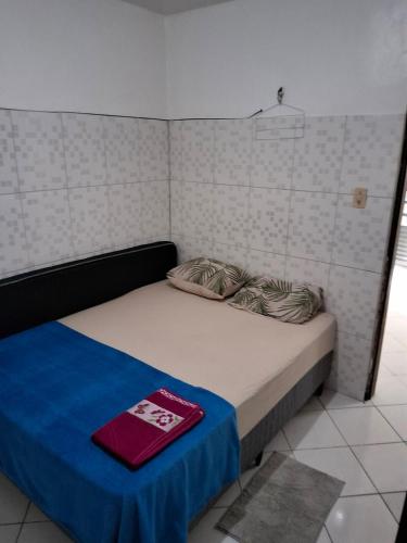 a small bed in a room with a blue blanket at Apto 04 em São Bras in Belém