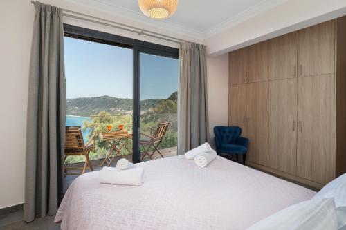 a bedroom with a bed and a large window at Irida sunset in Pentátion