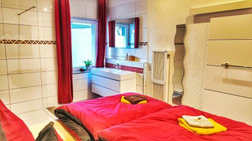 a room with a red bed and a sink at AMORE 69 bei Greta in Marl