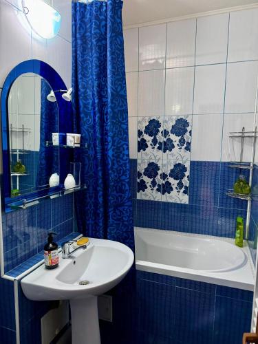 a blue and white bathroom with a sink and a tub at Sunset Home Apartment in Galaţi