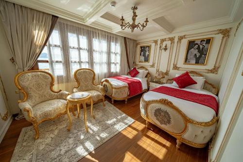 a bedroom with two beds and chairs and a chandelier at Princess Farida Luxury Dahabiya Nile Cruise, Every Monday from Luxor to Aswan 4 nights and Every Friday from Aswan to Luxor 3 nights in Luxor