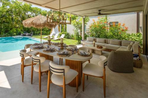 a dining room with a table and chairs and a pool at Luxury 5BR Villa with Pool Jacuzzi 2 Golf Carts in Punta Mita