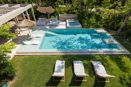 a swimming pool with two lounge chairs and a lawn at Luxury 5BR Villa with Pool Jacuzzi 2 Golf Carts in Punta Mita