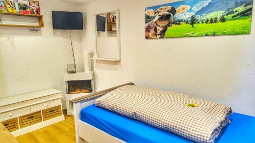 a room with a bed and a picture of a cow on the wall at STUGA bei GRETA in Marl