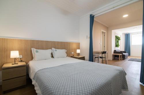 a bedroom with a large bed and a living room at Livramento Residence in Livramento