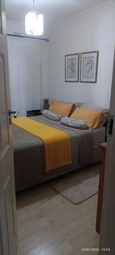 a bedroom with two beds with yellow sheets and a window at Bushman Kraal Lux in Soweto