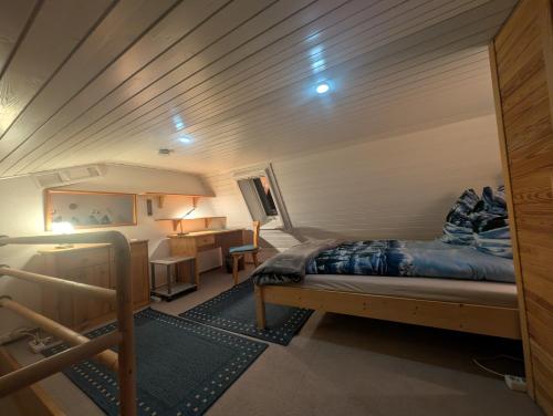 a bedroom with a bed and a desk in a room at Ferienwohnung Eule in Schönwald