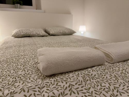 a bed with two pillows on top of it at Apartament w centrum Konina in Konin