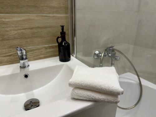a bathroom with a sink and a bottle of wine at Apartament w centrum Konina in Konin