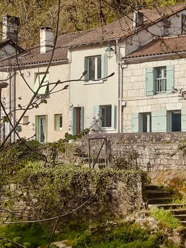 biały dom z kamiennym murem i schodami w obiekcie La Suzanne w mieście Brantôme