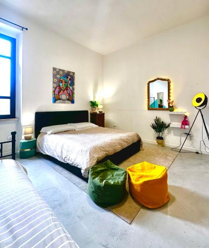 a bedroom with a bed and two green ottoman at Palazzo Pilo in Sassari