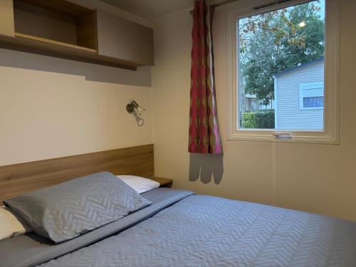a bedroom with a bed and a window at Chaleureux Tiny Home à 45 mn du Zoo de Beauval in Veuzain-sur-Loire