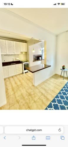 a kitchen with white cabinets and a black counter top at Apto 1 dormi in Capão da Canoa
