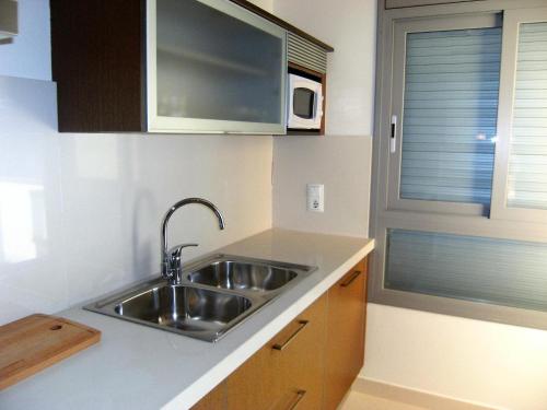a kitchen with a sink and a microwave at Apartment in Estartit with garden in L'Estartit