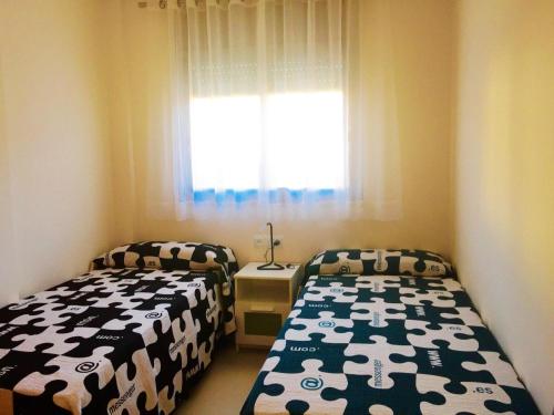 a bedroom with two beds and a window at Apartment in Estartit with garden in L'Estartit