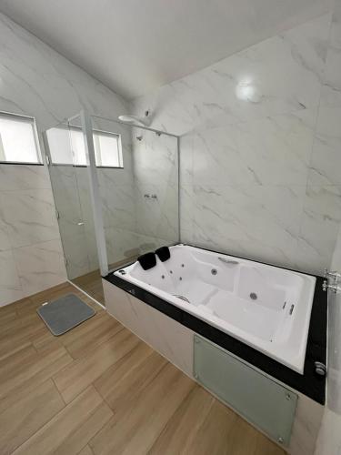 a large white bath tub in a room at Pousada Vida feliz in Águas de Lindoia