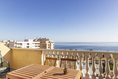 a table on a balcony with a view of the ocean at Penthouse Pink seafront in La Mata