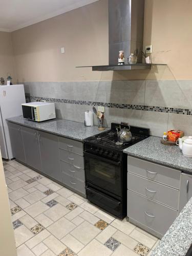 a kitchen with a stove and a refrigerator at Casita de Noe in Tandil