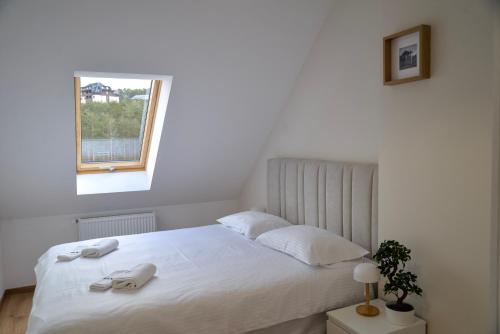 a bedroom with a white bed with a window at PANTEX Centar Zlatibor in Zlatibor