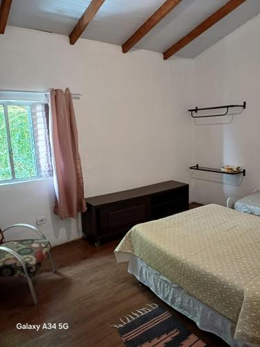 a bedroom with a bed and a window at Mar e descanso in São Sebastião