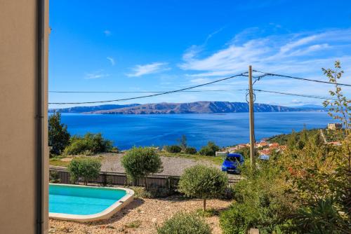 a house with a swimming pool and a view of the water at Villa The Sunset View in Nehaj