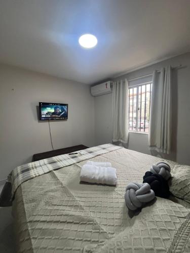 a bedroom with a large bed with a tv on the wall at Impera House Apt Térreo bairro Santa Inês in Imperatriz