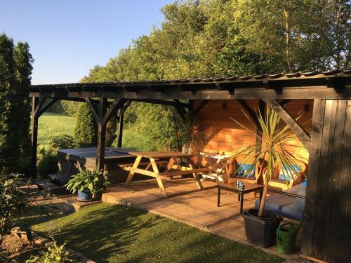 a wooden pergola with a picnic table in a garden at Holiday Home in Reutum with Bubble Bath in Beekdorp
